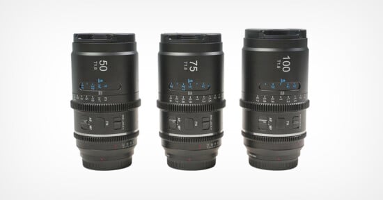 Three black camera lenses labeled 50mm, 75mm, and 100mm are standing upright in a row on a plain white background, showing detailed focus and aperture markings.