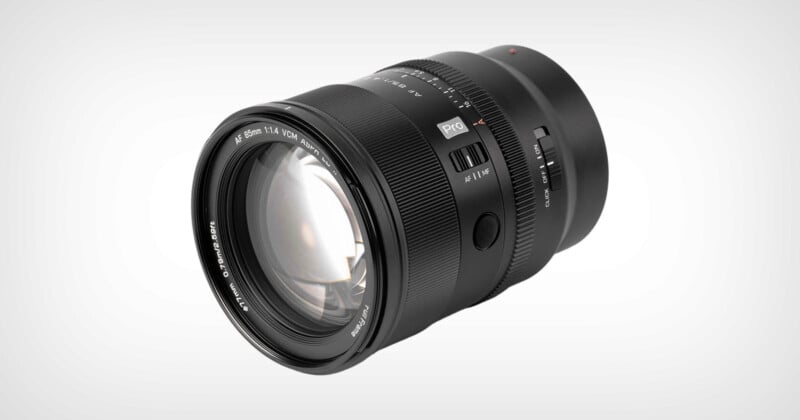 Lente de cámara negra con enfoque visible y anillo de apertura, etiquetada "85 mm 1:1,4 diámetro DG" y "sigma," Situado sobre un fondo gris claro liso.