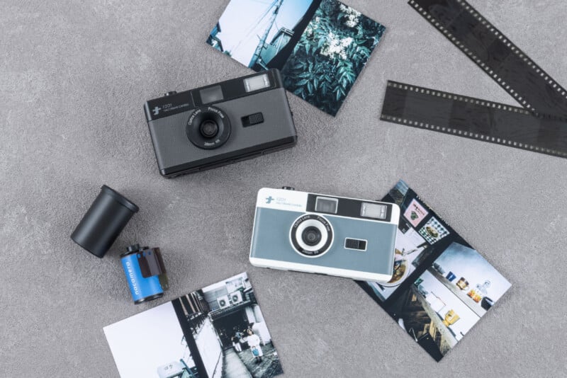 Dos cámaras de película antiguas, varias fotografías impresas, dos tiras de negativos de película y un rollo de película de 35 mm están dispuestos sobre una superficie con textura gris. Esta escena evoca una atmósfera nostálgica de fotografía analógica.