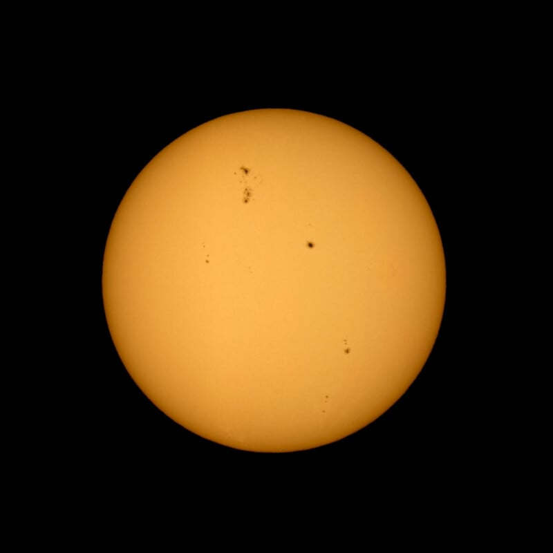 Las fotografías del Sol muestran un círculo amarillo anaranjado brillante sobre un fondo negro, con varias manchas solares negras esparcidas por su superficie.