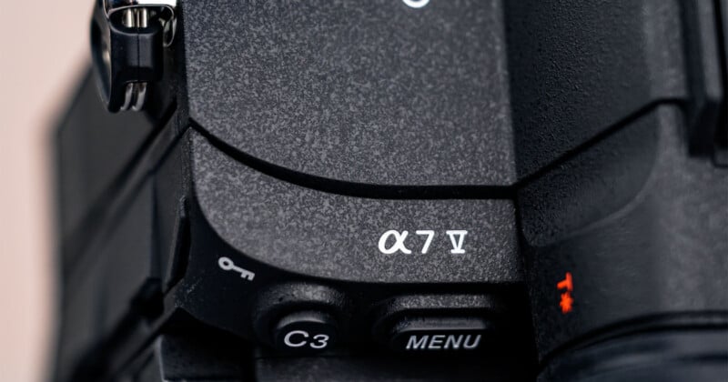 Close-up view of the controls on a Sony Alpha 7 IV camera, showing the model label “α7 IV” and buttons labeled “C3” and “MENU” on the textured black camera body.