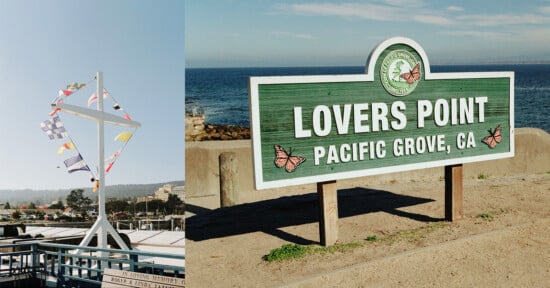 A green and white sign reading "Lovers Point, Pacific Grove, CA" stands near the ocean; next to it is a nautical mast with colorful signal flags at a seaside pier under a clear blue sky.