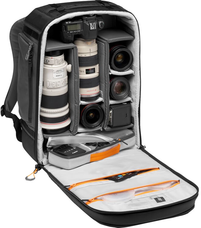 La mochila para cámara se abre para revelar compartimentos organizados para el cuerpo de la cámara, múltiples lentes de cámara, accesorios y equipos pequeños, así como un bolsillo adicional con cremallera en el interior de la solapa.