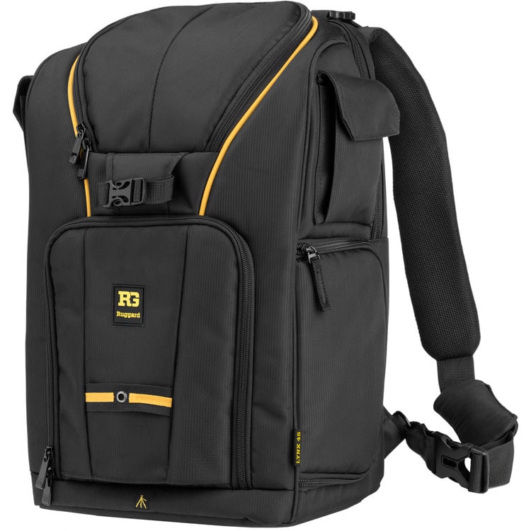 Esta mochila Rugged negra con detalles en amarillo cuenta con correas acolchadas para los hombros, múltiples compartimentos con cremallera y una solapa frontal con el logotipo de RG Rugged.