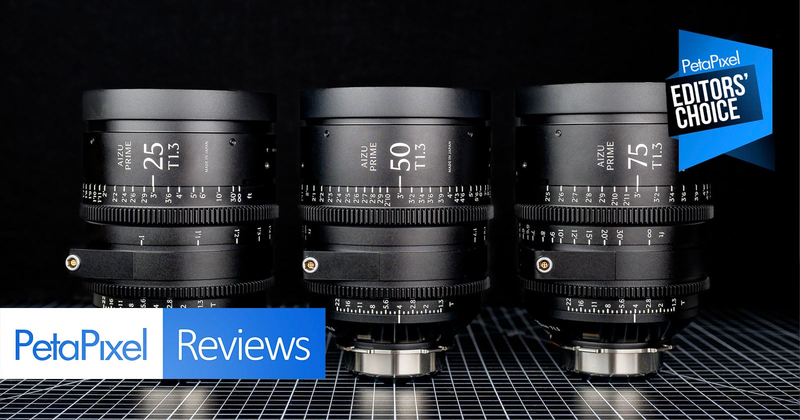 Three black camera lenses are arranged side by side on a grid-patterned surface, with “Petapixel Reviews” and “Editors' Choice” badges displayed in the image corners.