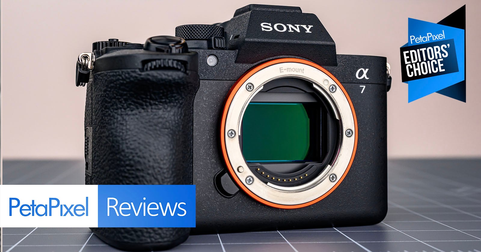 A Sony Alpha 7 camera body is displayed on a gray grid surface. "PetaPixel Reviews" and "Editors’ Choice" banners appear on the image, indicating a positive camera review.