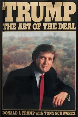 La portada del libro es "Trump: el arte del trato" Muestra un retrato de Donald Trump con traje y corbata roja, con árboles al fondo. El título está en texto dorado grande en la parte superior y el nombre del autor en la parte inferior.