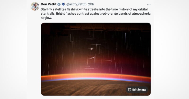 A photograph of white streaks from Starlink satellites crossing the sky above Earth’s horizon, with red-orange atmospheric airglow and space in the background. The image is shared in a tweet by Don Pettit.