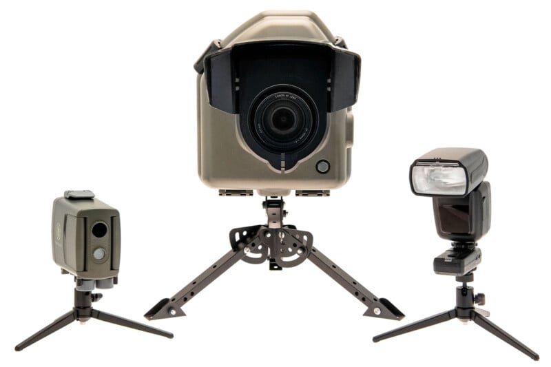 Three camera devices on tripods: a large central camera with lens hood, flanked by a smaller device with dual sensors on the left and a detachable camera flash unit on the right, all on white background.