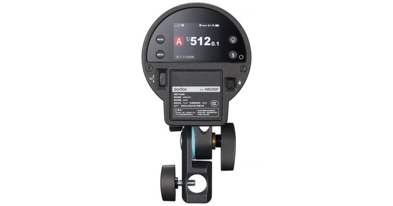 Vista trasera de un dispositivo electrónico redondo que muestra una pantalla digital con botones y una batería con la etiqueta 