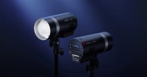 Two black Godox AD300Pro studio lights are shown against a dark blue background, one facing forward displaying the bulb, and the other facing backward showing the control screen and buttons.