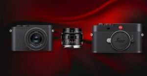 Three Leica camera products displayed on a dark red and black gradient background: a compact camera on the left, a camera lens in the center, and a camera body on the right.