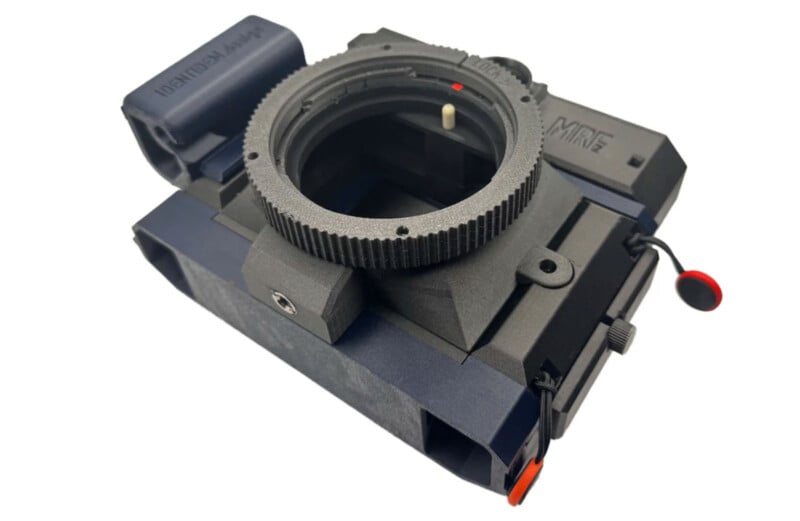 A close-up view of a black and gray 3D-printed camera adapter with a large mount ring, red accents, and various textured surfaces.