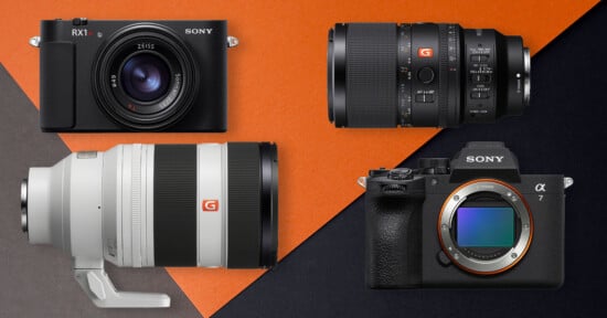 Four Sony camera products on a black and orange background: two cameras (one compact, one mirrorless with no lens) and two interchangeable lenses, including a large telephoto lens and a shorter zoom lens.