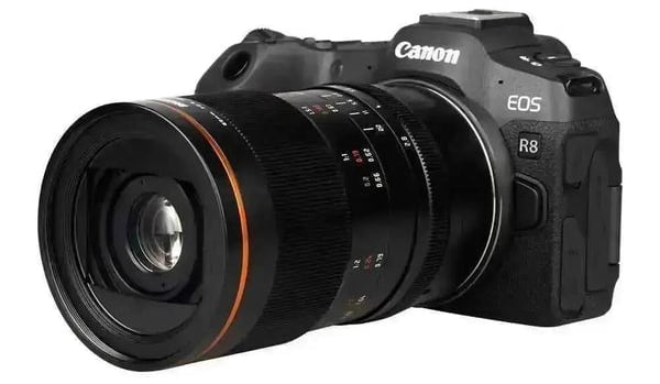 A black Canon EOS R8 digital camera with a large detachable lens, angled slightly to the right, showing brand and model name clearly.