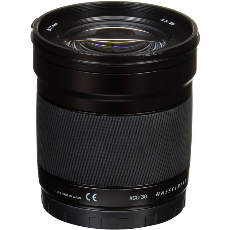 A black Hasselblad XCD 30mm camera lens standing upright on a white background, showing the front glass element and brand markings around the barrel.