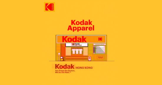 Illustration of a Kodak storefront labeled "Kodak Apparel" with shirts and film in the window, set on a yellow background. The Kodak logo appears at the top left and above the store. Text reads: "You Press the Button, We do the Rest.