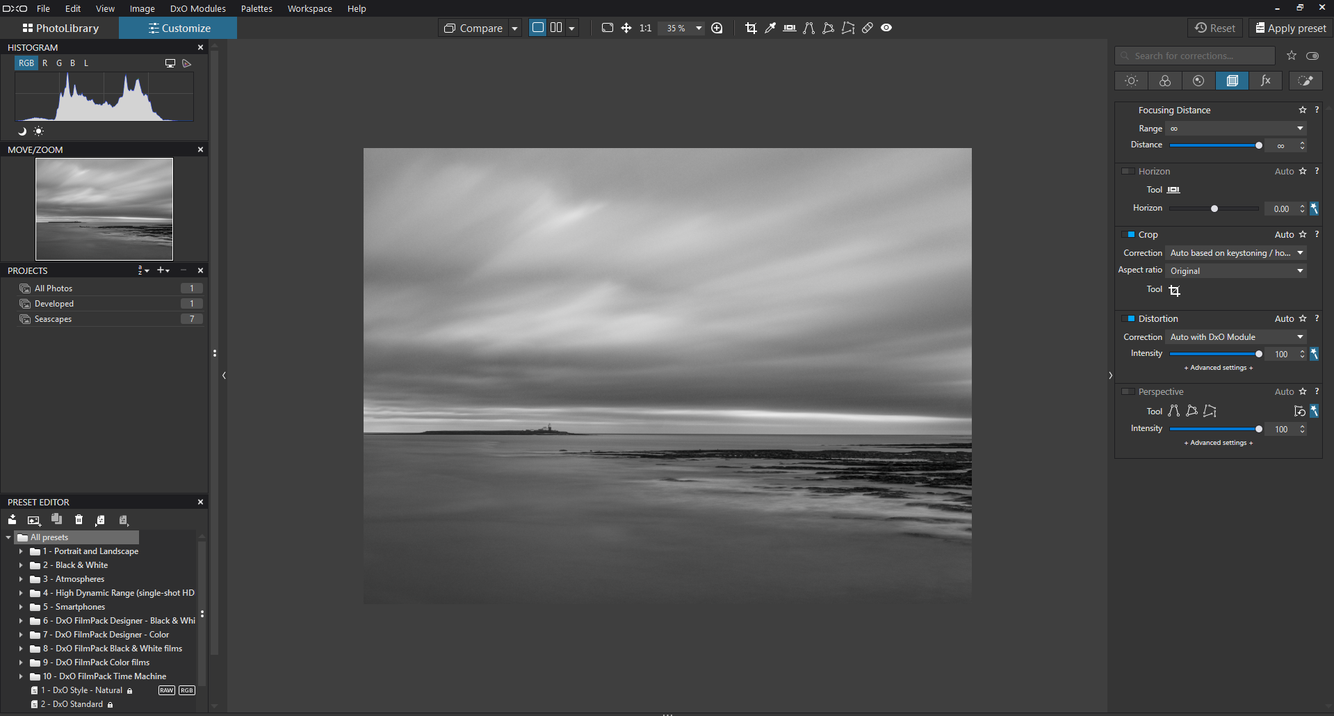 A photo editing software interface displays a black and white seascape with a distant island. Editing tools and adjustment sliders are visible on the right, with a project list and histogram on the left.