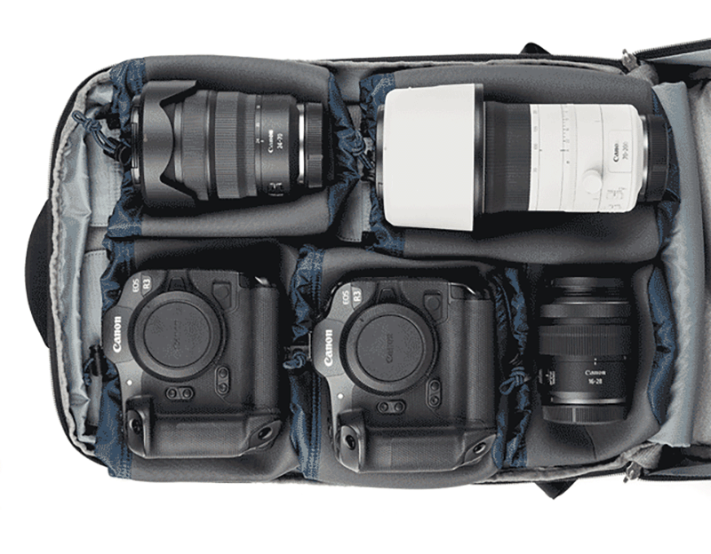 Un bolso para cámara que contiene dos cámaras Canon DSLR y tres lentes intercambiables, todos cuidadosamente ordenados en compartimentos acolchados para protección y organización.