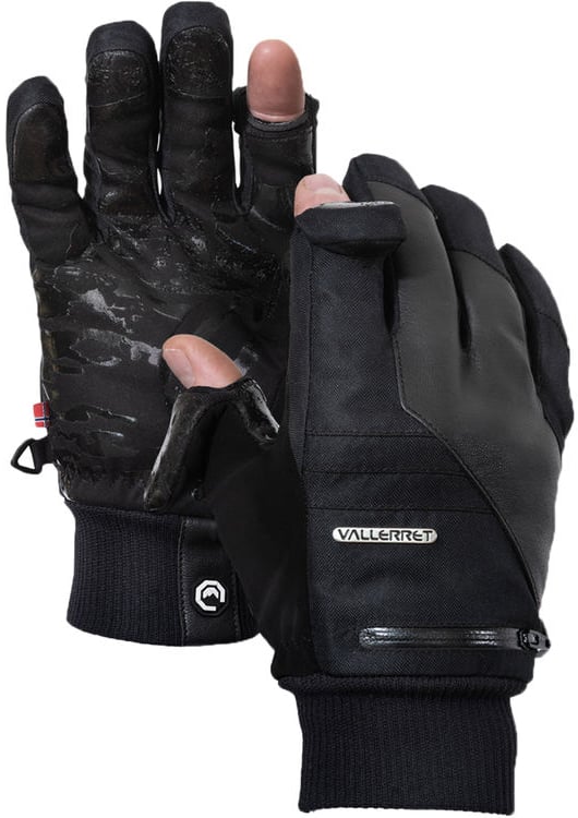 A pair of black Vallerret winter gloves with the thumb and index finger tips flipped open, revealing bare fingers. The gloves feature a small zipper pocket and textured palms for grip.