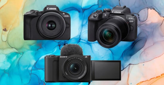 Three digital cameras (two Canon models and one Sony with a flip-out screen and microphone) are displayed against a colorful, abstract background with blue, yellow, and pink marbled patterns.