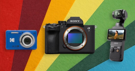 Three cameras—a blue Kodak compact, a Sony Alpha mirrorless, and a DJI Osmo Pocket—are displayed side by side against a colorful, striped, textured background.