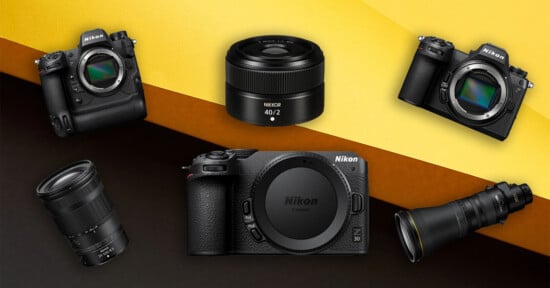 Several Nikon cameras and lenses are arranged on a yellow and orange background, including camera bodies and close-up views of various interchangeable lenses.