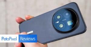 A hand holds a black HONOR smartphone, showcasing its large circular rear camera module. The image features a "PetaPixel Reviews" banner in the lower left corner.