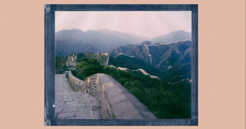 Una fotografía estilo Polaroid de la Gran Muralla China serpenteando sobre verdes colinas y montañas bajo un cielo brumoso, con caminos de piedra y ladrillos visibles en primer plano.