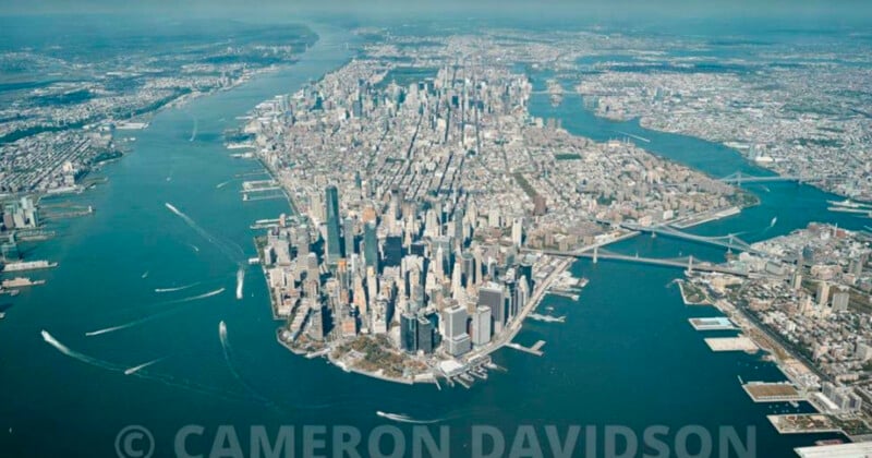 Vista aérea de Manhattan, Nueva York, en un día despejado, que muestra el denso grupo de rascacielos, el río circundante y los puentes que conectan los otros distritos.