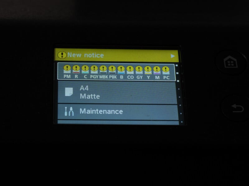 La pantalla de la impresora muestra varios íconos de advertencia amarillos para diferentes niveles de tinta, incluidos "Matemáticas A4" y "mantener" Opciones enumeradas a continuación "nueva notificación" información.