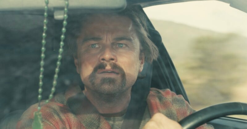 Un hombre de aspecto severo y barba de chivo conducía el coche, agarrando con fuerza el volante. Cuentas verdes colgaban del espejo retrovisor y el paisaje fuera de la ventana estaba borroso.