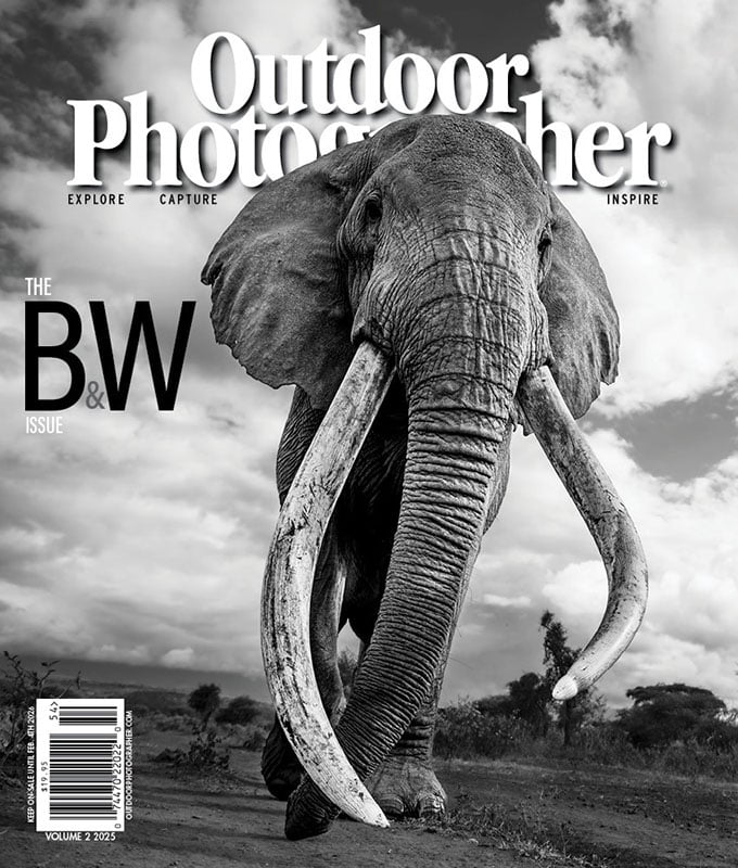 Portada de revista en blanco y negro, primer plano de un elefante con grandes colmillos caminando hacia adelante bajo un cielo nublado, titulado "Fotógrafos de exteriores: cuestiones en blanco y negro.