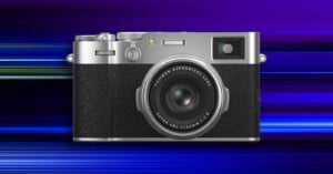 A silver and black Fujifilm camera with a large lens is centered against a vibrant, blue and purple striped background with a motion blur effect.