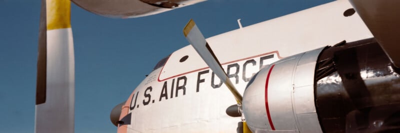 Close-up view of a U.S. Air Force aircraft, focusing on the propeller engine and part of the fuselage, with blue sky in the background. The words "U.S. AIR FORCE" are clearly visible on the plane.