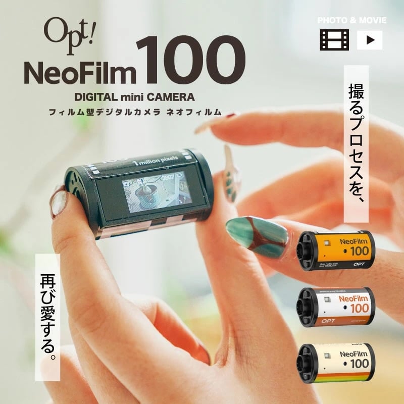 A hand holds a compact digital mini camera shaped like a film roll. Three colorful film roll designs are displayed below. Japanese and English text describes the NeoFilm 100 camera and its nostalgic appeal.