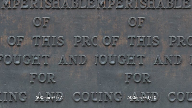 Side-by-side comparison of engraved text on a metal plaque. The left side is labeled "500mm @ f/7.1" and the right, "500mm @ f/10," showing differences in text sharpness and clarity between camera aperture settings.