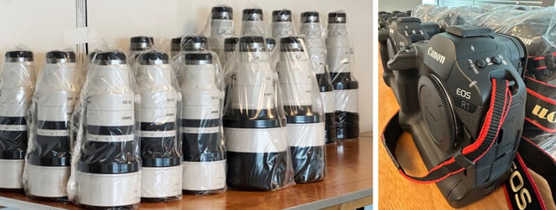 Sobre la mesa hay una fila de grandes teleobjetivos Canon envueltos en plástico. A la derecha se pueden ver tres cuerpos de cámara Canon EOS y correas rojas para el cuello.
