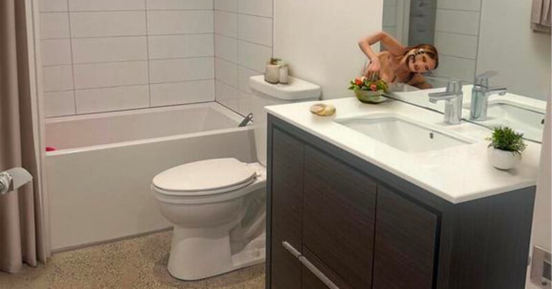 A woman in a brown dress is humorously leaning through a bathroom mirror, reaching for a bowl of fruit on the counter. The bathroom is modern with a bathtub, toilet, and plants as decor.