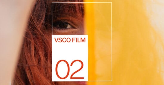 A close-up of a person’s face partially obscured by yellow fabric, with text “VSCO FILM 02” in a white box with orange letters and numbers overlaying the image.