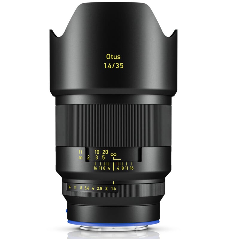 A black camera lens with a petal-shaped lens hood, labeled "Otus 1.4/35" in yellow text, featuring detailed focus and aperture markings in yellow and white.