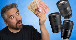 A surprised man holds a fan of Canadian dollar bills in one hand while looking at three large camera lenses floating beside him, with a blue checkered background.