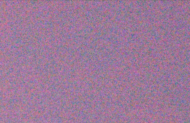 Un patrón multicolor de estática o ruido llena la imagen con pequeños puntos de color púrpura, rosa, azul, verde y rojo distribuidos aleatoriamente, similar a la estática de la televisión o al ruido digital.