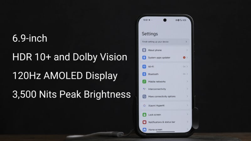 A smartphone displaying its settings screen is on a dark surface. Text beside it highlights features: 6.9-inch display, HDR 10+ and Dolby Vision, 120Hz AMOLED display, and 3,500 nits peak brightness.