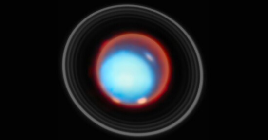 A bright, glowing blue and red circular object with a glowing center, surrounded by faint concentric rings, set against a black background. The image resembles an abstract or cosmic scene.