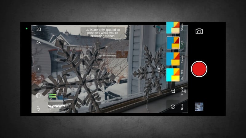 A smartphone camera app interface displays a snowy residential scene through a window with snowflake decorations. Various camera controls and LUT (color filter) options appear on the right side of the screen.