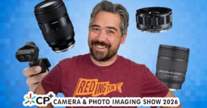 A smiling man in a red "REDINGTON" shirt holds a camera, surrounded by four camera lenses, in front of a blue pixelated background. Text at the bottom reads "CP+ Camera & Photo Imaging Show 2026.