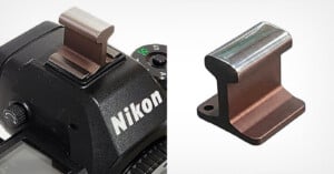 A metal accessory shaped like a miniature railroad rail, shown installed on the hot shoe of a Nikon camera on the left, and separately on the right against a white background.