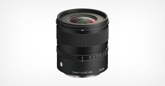 A black Sigma 15mm f/1.4 DC DN camera lens shown against a white background, with visible focus and aperture rings, lens markings, and a prominent front glass element.