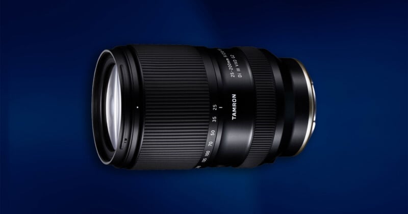 A Tamron camera lens with zoom and focus rings, shown against a dark blue gradient background.